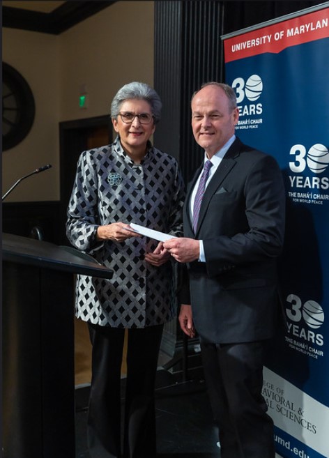 hoda mahmoudi receiving a check from kenny bowers