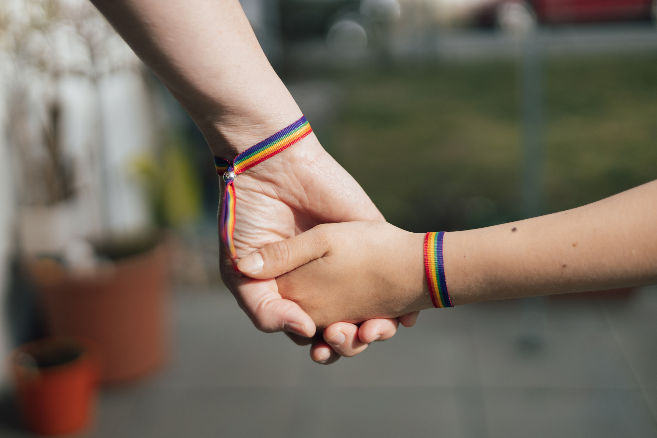 mother and daughter holding hands wearing rainbow bracelets