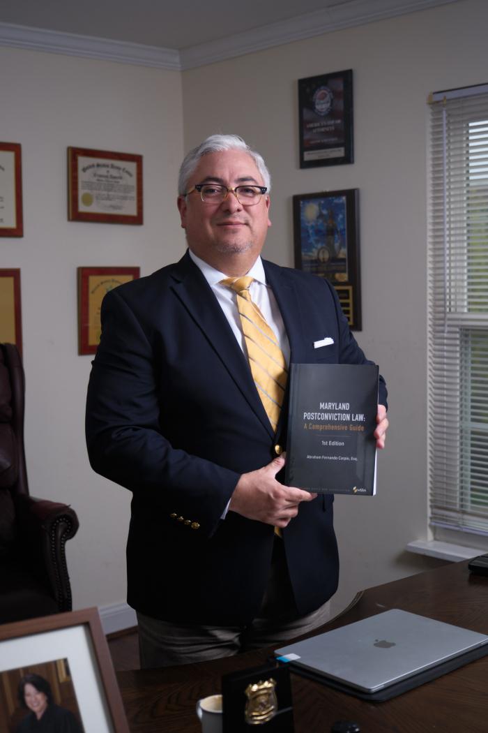 Photo of UMD BSOS GVPT alumnus Abraham Carpio holding his book, "Maryland Post-Conviction Law: A Comprehensive Guide"