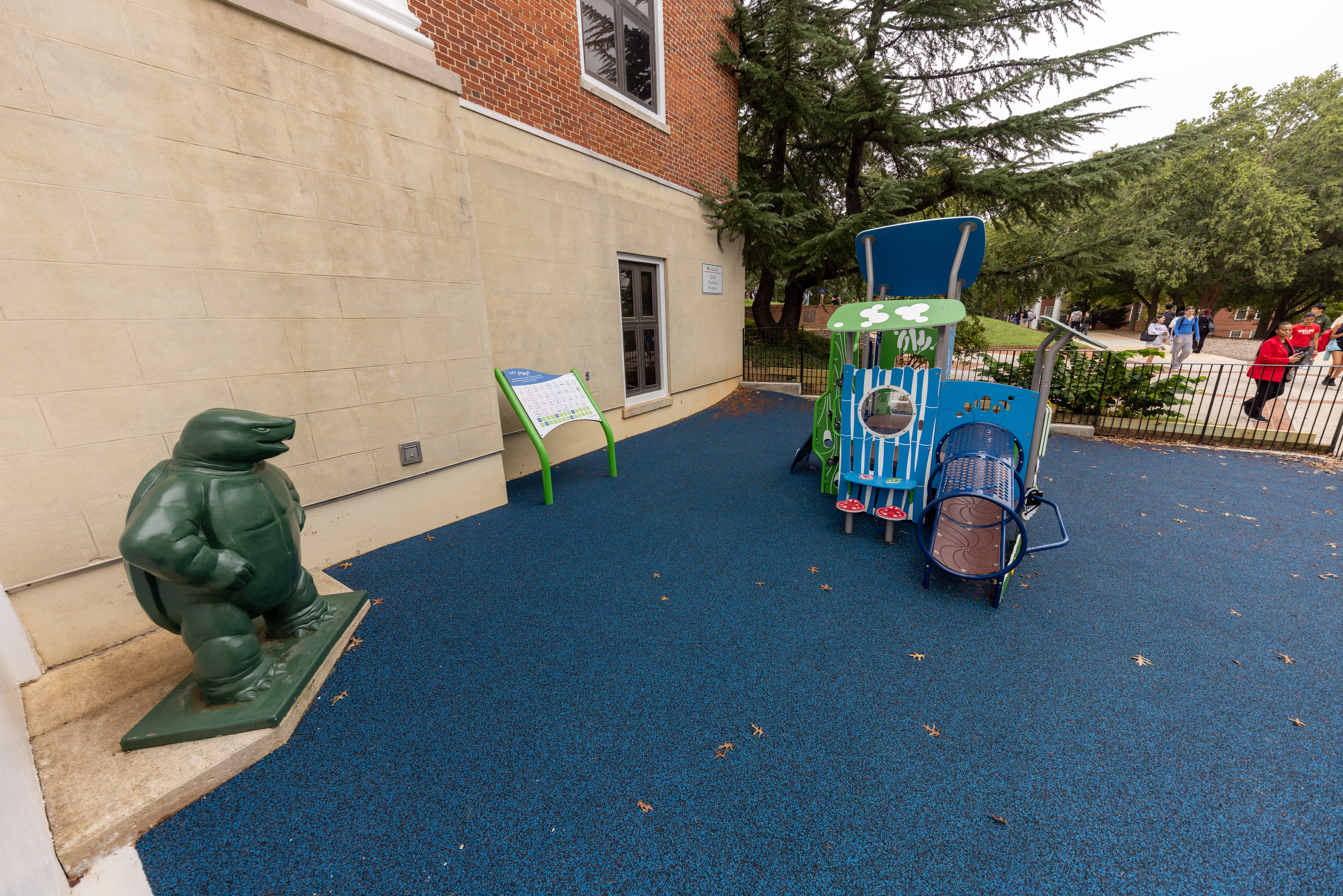 side shot of the new UMD LEAP preschool program playground, featuring a communication board to the right of the playset