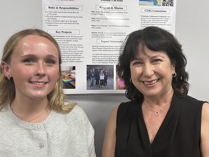 Emma Parsons, left, and Dean Susan Rivera, right, in front of Emma's poster about the Maryland Mentor Corps