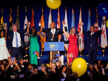 photo of wes moore raising hands in victory on stage on election night 2022