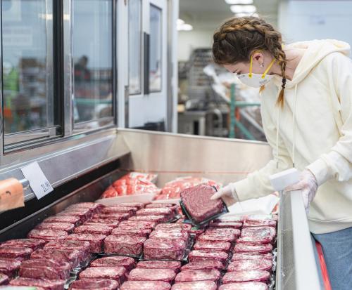 woman buying meat at a grocery store