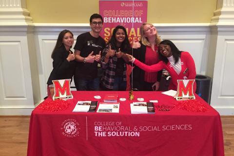 Ambassadors smiling behind BSOS table at Open House.