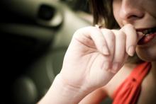 Woman bites fingernails nervously.