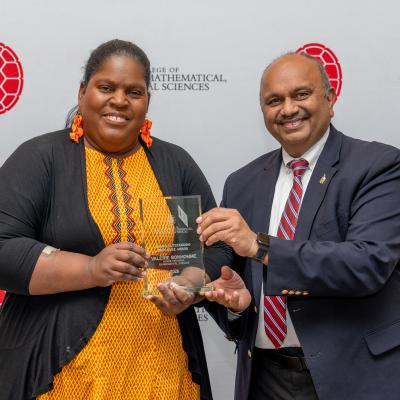 Photo of Val Bonhomme, UMD GEOG '00, receiving an award from the Dean of the UMD College of Computer, Mathematical and Natural Sciences