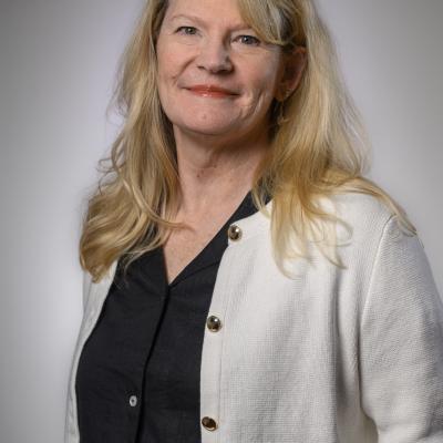 Professional headshot photo of Karen Albert, an alumna of the BSOS Department of Sociology, wearing a black shirt and white sweater