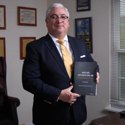 Photo of UMD BSOS GVPT alumnus Abraham Carpio holding his book, "Maryland Post-Conviction Law: A Comprehensive Guide"
