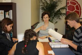 Photo of Kathryn Hopps sitting at a table talking with students in the University Career Center